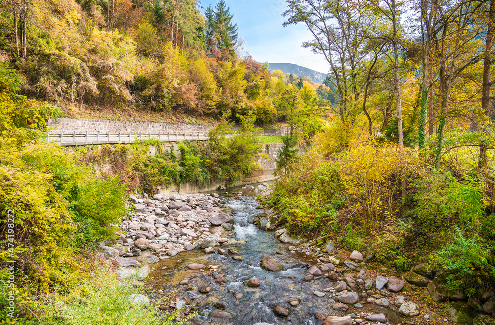Magnificent landscape of a mountain river between large stones, an autumn forest, a highway and mountains Magnificent landscape of a mountain river between large stones, an autumn forest, a highway and mountains