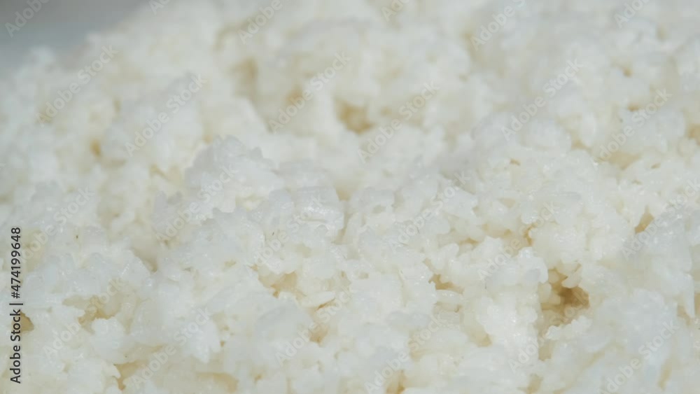 A close-up of freshly cooked Japanese rice for sushi. Making Japanese sushi rice, close up panorama on cooked and seasoned sushi rice. The camera moves from left to right.Slow motion. A close-up of freshly cooked Japanese rice for sushi. Making Japanese sushi rice, close up panorama on cooked and seasoned sushi rice. The camera moves from left to right.Slow motion.