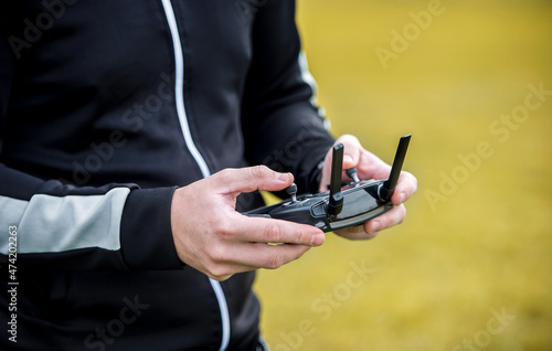 Man operating the drone by remote control, close up photo. Concept of cybernetics and robotics