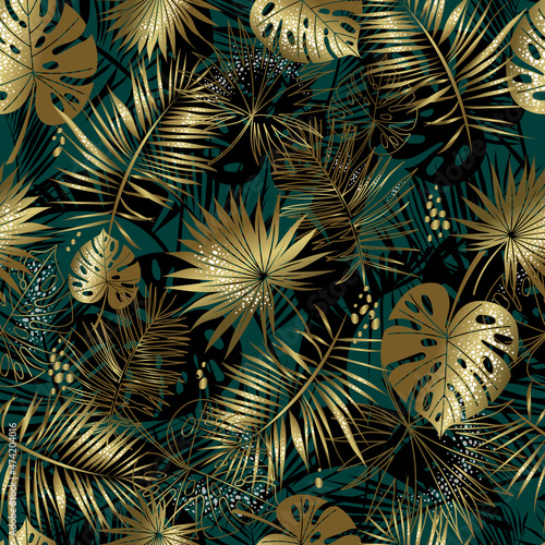 Seamless pattern of golden palm leaves and monstera on a dark emerald background. Includes black silhouette of leaves. Tropical botanical pattern. Elegant vector for print and for your design.