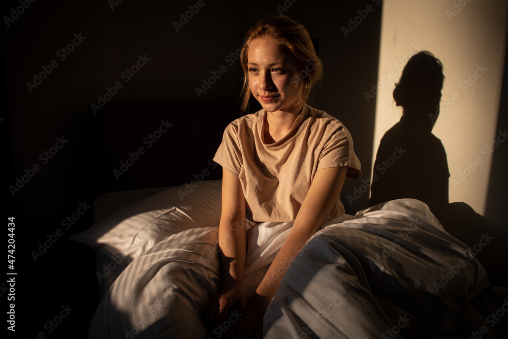 awake woman yawning in bed in sunny room and smiling at camera, young beautiful woman sitting in bed, newly awakened woman sitting on her bed touching her hair awake woman yawning in bed in sunny room and smiling at camera, young beautiful woman sitting in bed, newly awakened woman sitting on her bed touching her hair