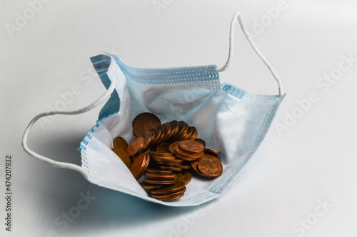 The pandemic purse - Protective mask filled with euro cents, concept to demonstrate the economic impoverishment due to the pandemic