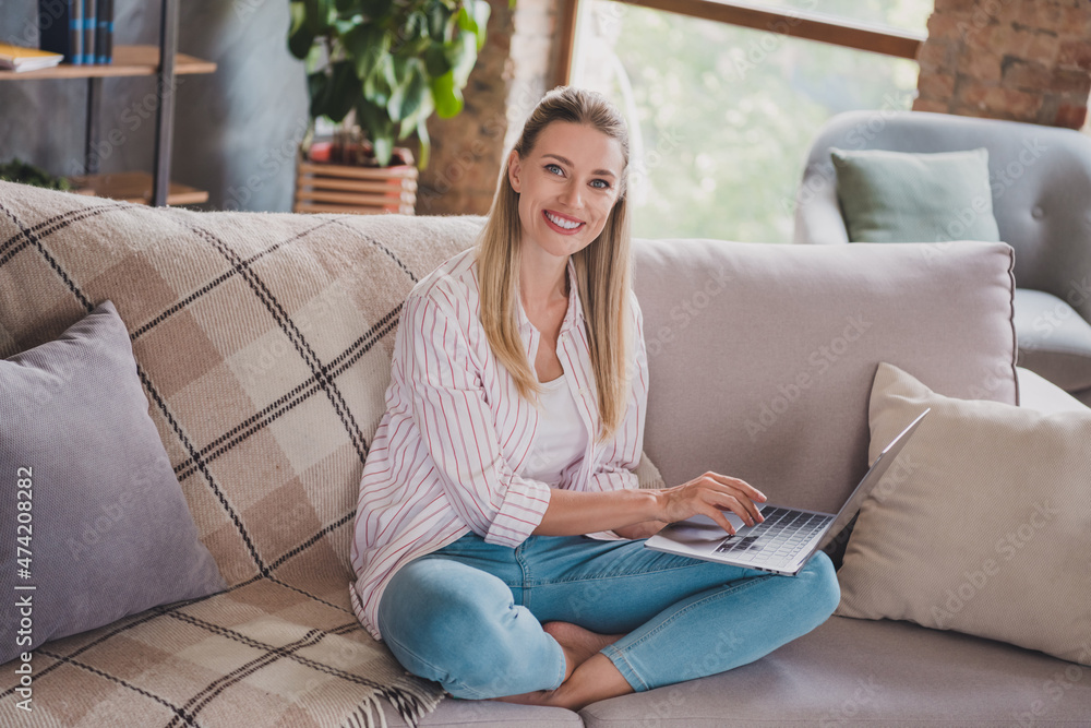 Full size photo of clever young blond lady sit working laptop wear shirt jeans at home on weekend vacation alone Full size photo of clever young blond lady sit working laptop wear shirt jeans at home on weekend vacation alone