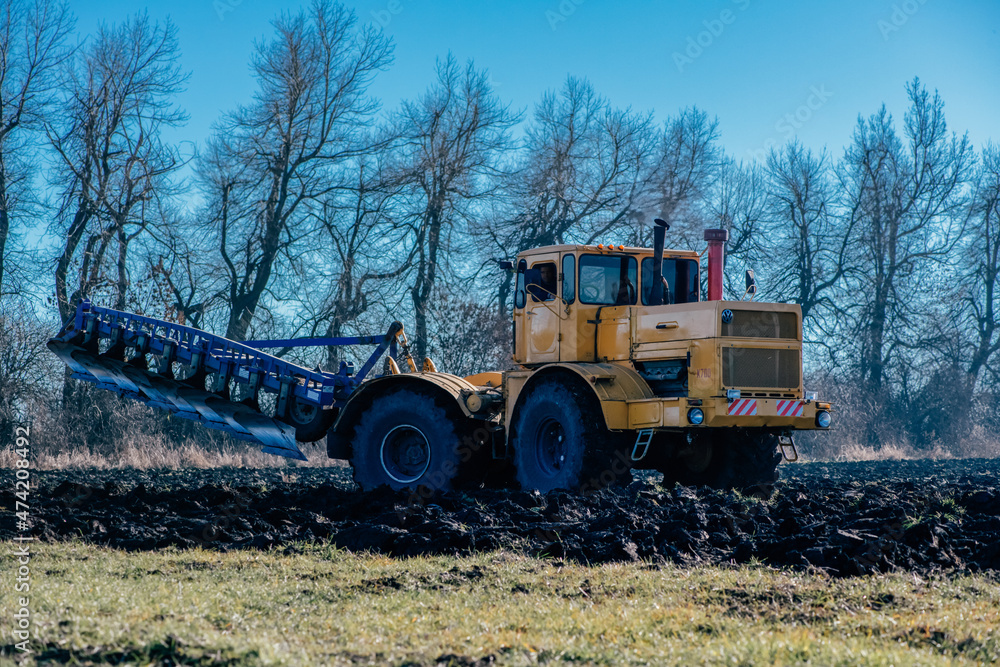 Obraz premium the tractor plows the land