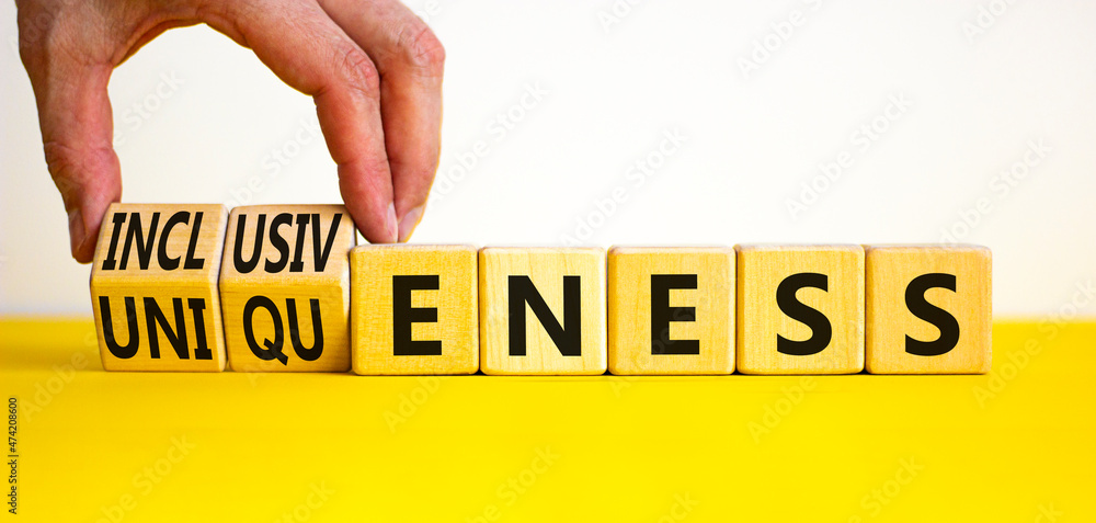 Inclusiveness and uniqueness symbol. Businessman turns wooden cubes ...