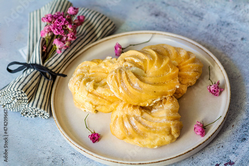 Home made eclairs with vanilla cream in a plate 