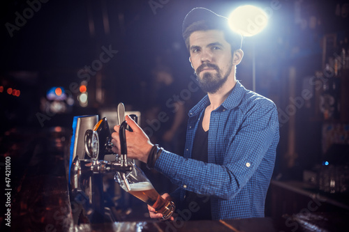 Portrait of barman makes a cocktail behind the bar photo