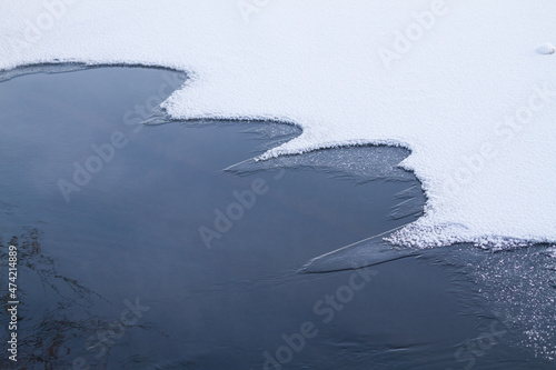 Ice and snow on water surface. Frosted and covered with ice and snow river water. photo