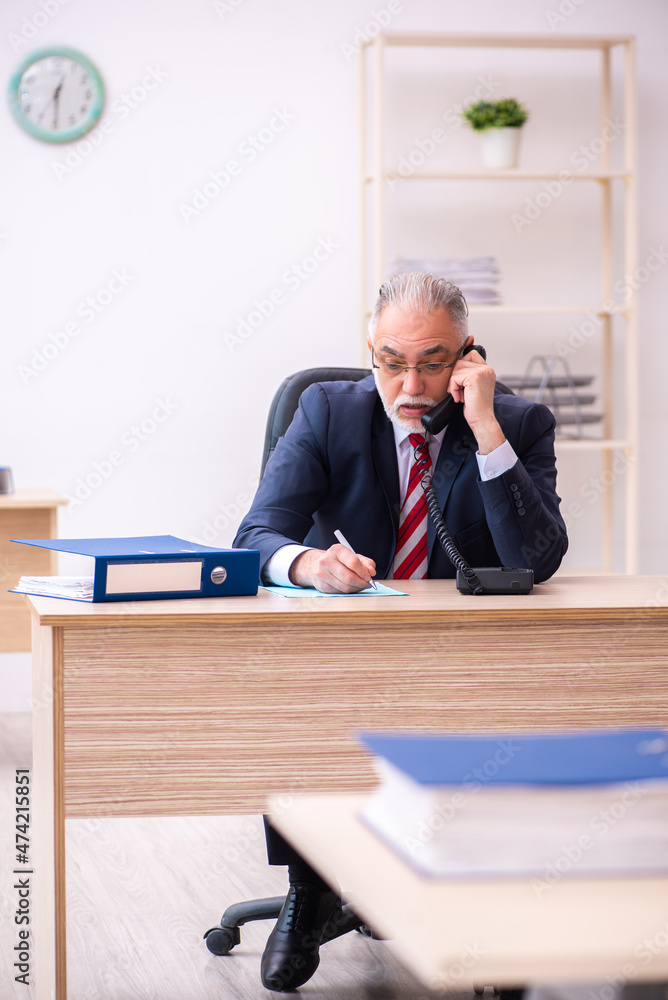 Old businessman employee sitting in the office Old businessman employee sitting in the office