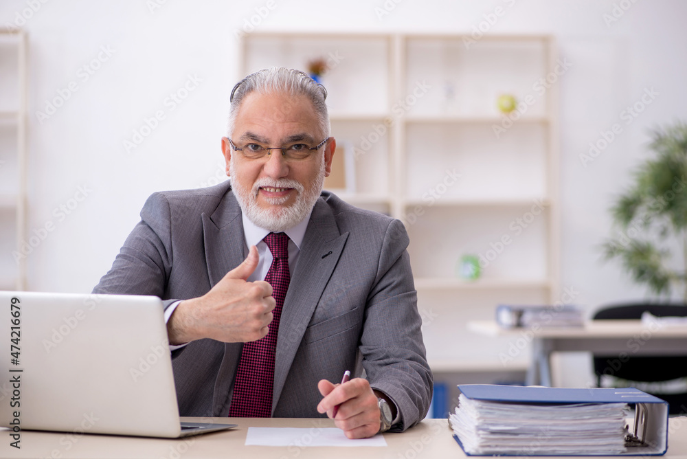 Old male employee working in the office Old male employee working in the office