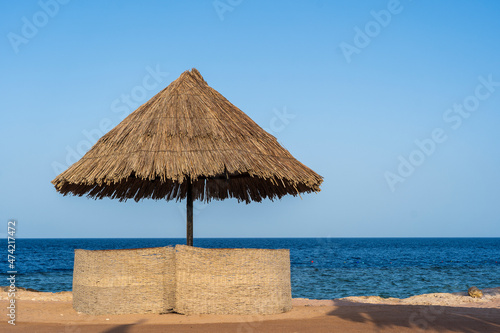 Fototapeta Naklejka Na Ścianę i Meble -  Luxury sand beach with beach chairs and straw umbrellas in tropical resort in Red Sea coast in Egypt, Africa