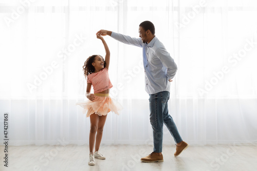 Fotografía Black father and daughter dancing at home, full length shot