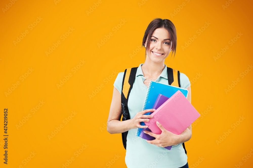 Smiling woman student with school books in hands on the background. Smiling woman student with school books in hands on the background.
