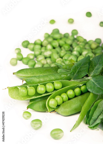Pods of green peas with pea leaves and flowers isolated on a white background. Organic food.