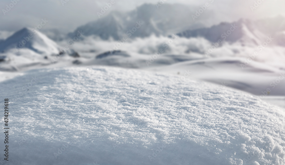 Fresh snow against the backdrop of a beautiful mountain landscape and the sun in the background Fresh snow against the backdrop of a beautiful mountain landscape and the sun in the background