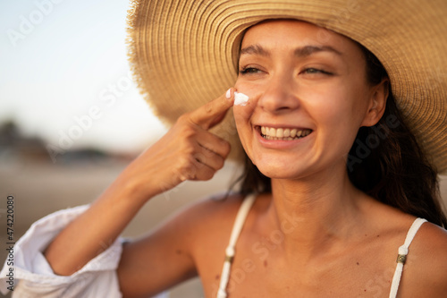 Woman using sunscreen cream. Beautiful girl with sun protection cream.