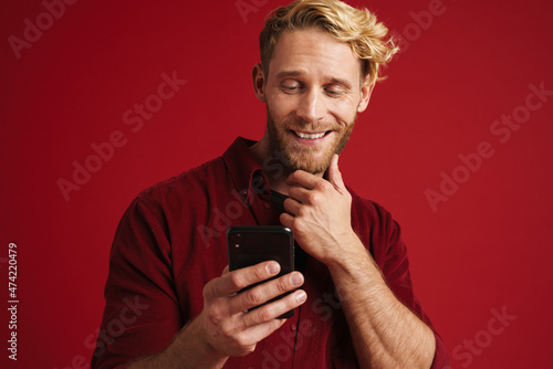 White bearded man wearing shirt smiling and using cellphone © Drobot Dean