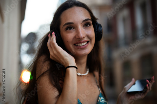 Beautiful young elegance woman using the phone. Beautiful fashion woman listening the music..
