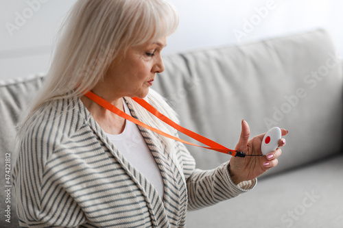 Emergency call system. Senior woman holding Alarm Button photo