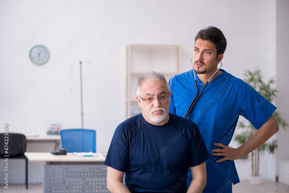 Obraz premium Old man visiting young male doctor