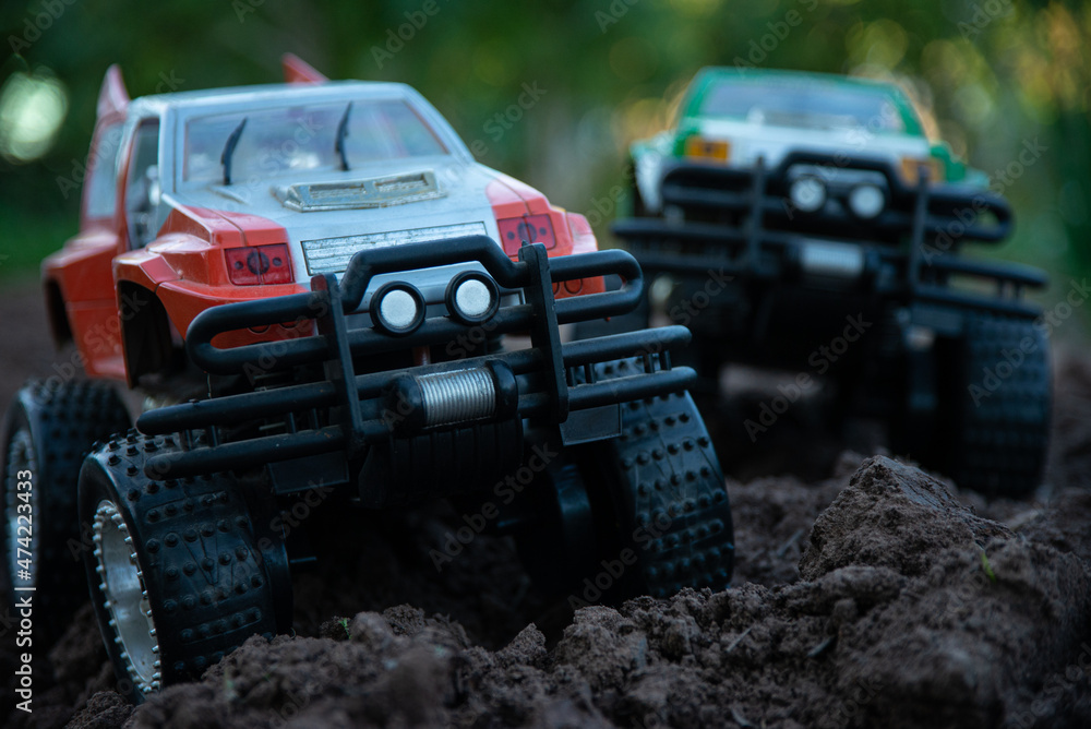 Obraz premium Bigfoots race on rough ground, tightening moves. 4 Wheels