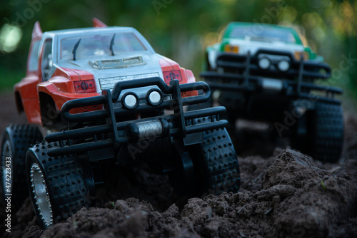 Bigfoots race on rough ground, tightening moves. 4 Wheels