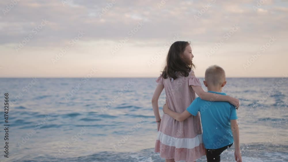Farewell to the sea. A little boy and a girl are hugging each other on the seashore. Farewell to the sea. A little boy and a girl are hugging each other on the seashore.