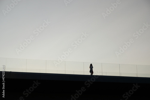 Obraz na płótnie silhouette of a female walking on a bridge w salonie