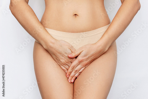 Fotografía Cropped shot of a young woman in underwear holding her crotch with her hands, suffering from cystitis isolated on white background