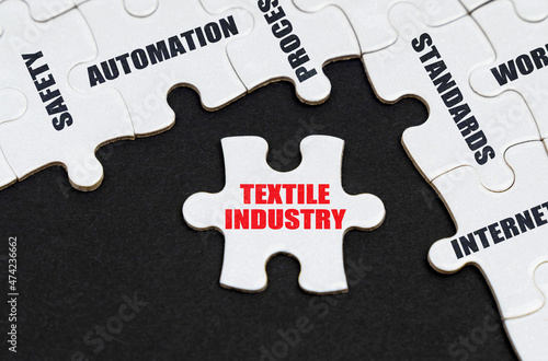 On a black background, puzzles with inscriptions, on a separate puzzle there is an inscription - Textile industry photo