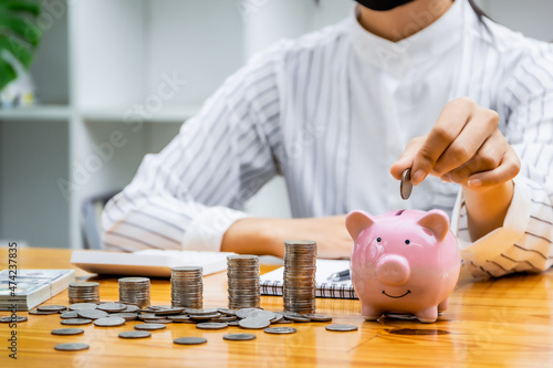 A businessman puts a coin in a piggy bank . A women saves money for household expenses. utility bills Monthly Family Budget Calculation Investment or personal savings strategy.