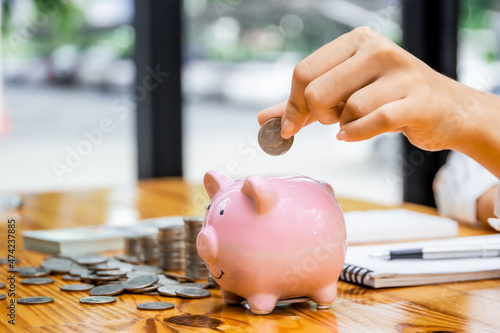 A businessman puts a coin in a piggy bank . A man saves money for household expenses. utility bills Monthly Family Budget Calculation Investment or personal savings strategy.