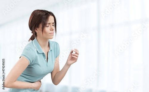 Young woman with arms on stomach and bending over with menstrual pain expression Free Download Young woman with arms on stomach and bending over with menstrual pain expression - GFXLoad