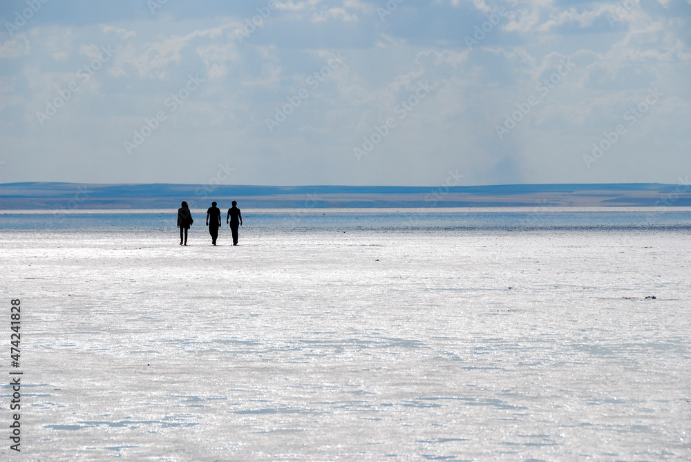 Tuz Lake, Turkey. Three people walking in the arid landscape. The second largest lake in Turkey. The area it covers is divided between the Turkish provinces of Ankara, Konya and Aksaray.