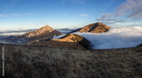 Mala Fatra, Lesser Fatra, Slovakia, Europe. Velky Rozsutec and Stoh, mountain and peak lit by evening light at golden hour. Landscape and nature in autumn and fall. Clouds and inversion in the walley.