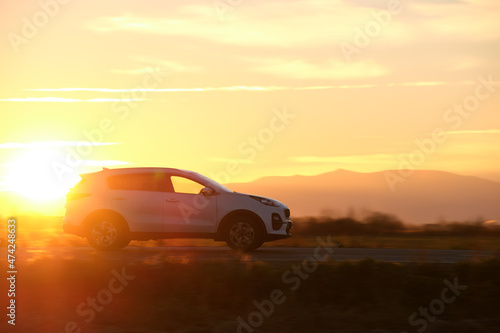 Car driving fast on intercity road at sunset. Highway traffic in evening © bilanol