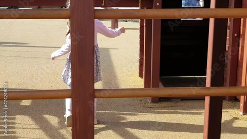 a girl climbs a wooden slide on a playground in the park photo