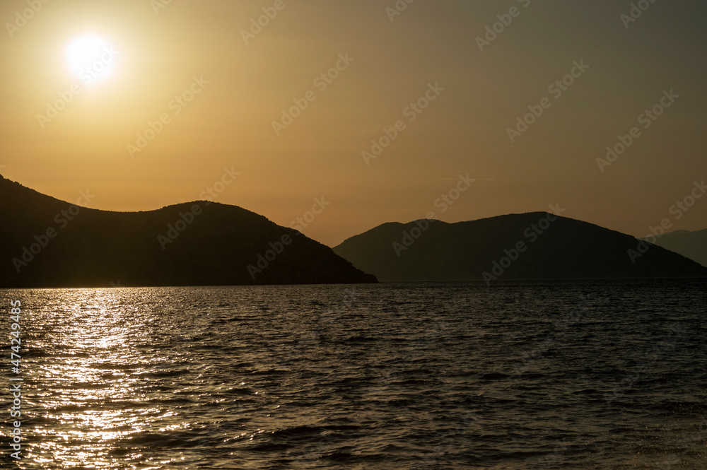 View of a seunset over Aegean Sea Greek islands. Hills silhouett