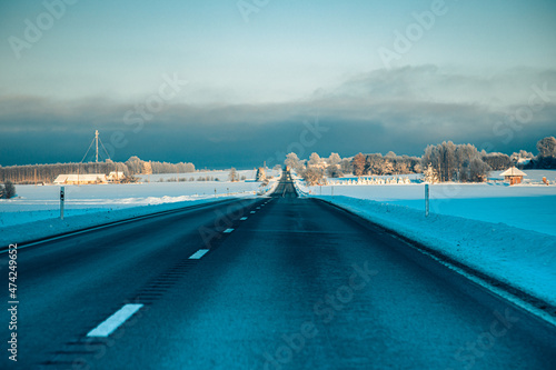Winter asphalt road.  Winter road and trees with snow and Latvian landscape. Soft focus on photos. © Emvats