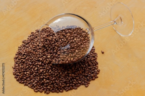 Obraz na płótnie
Lying wine glass with a scattering of grape seeds on a wooden texture background w salonie