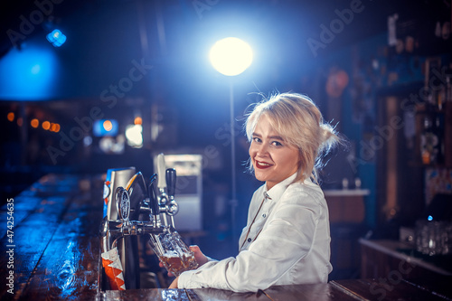 Girl barman makes a cocktail on the alehouse photo