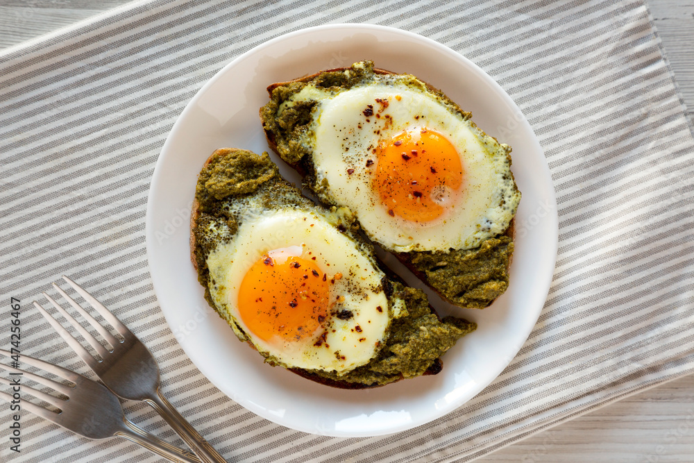 Homemade Pesto Egg Toast on a white plate, top view. Flat lay, overhead, from above. Homemade Pesto Egg Toast on a white plate, top view. Flat lay, overhead, from above.