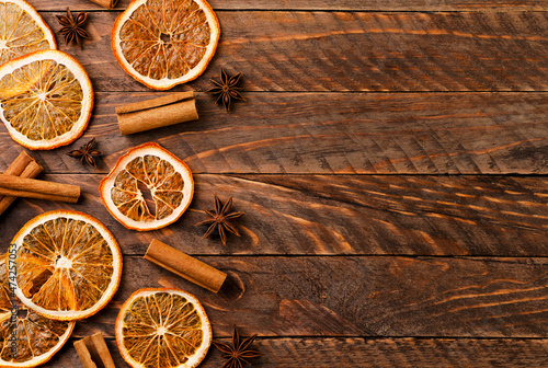 Dried orange, cinnamon and star anise on a wooden background, top view. Christmas background