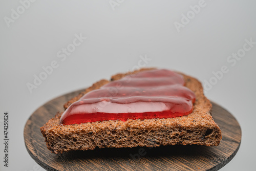 Rye bread toast with strawberry jam on a wooden tray