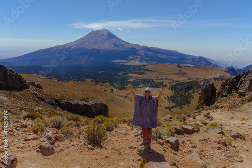 a man standing with the popocatepetl volcano in the background