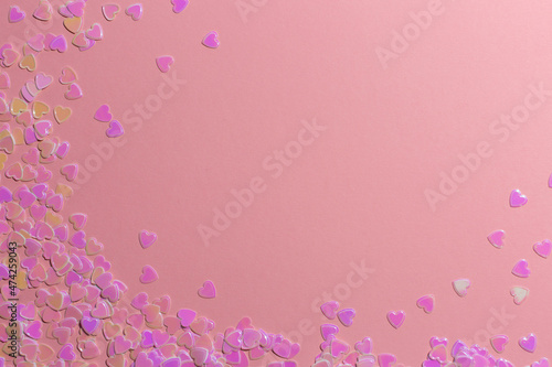 sequins-confetti in the shape of hearts on a pink background. valentine's day concept © Natalya Ugryumova