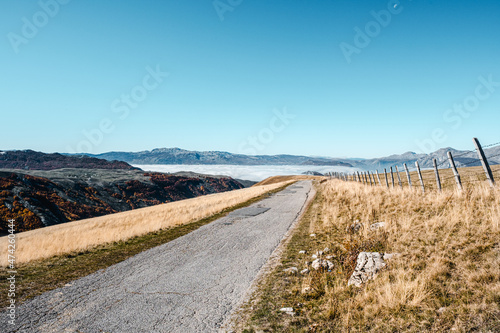 Country road in the mountains that follows a straight line towards the horizon