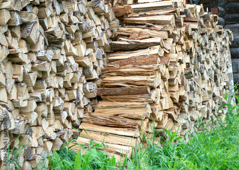 The split firewood is stacked in a woodpile. The split firewood is stacked in a woodpile.