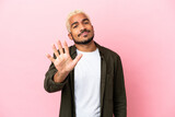 Young Colombian handsome man isolated on pink background counting five with fingers