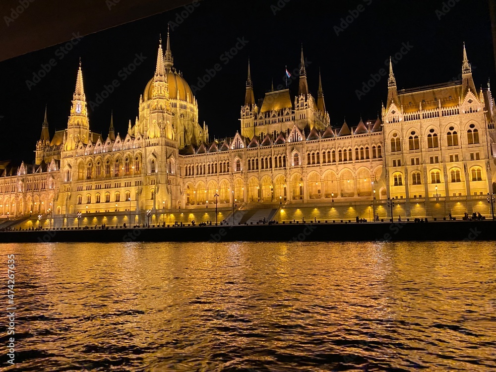 Illuminated Parliament building of Budapest at night with dark sky and reflection in Danube river